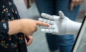 Child touching the finger of a robotic hand