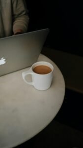 Coffee mug beside an open laptop