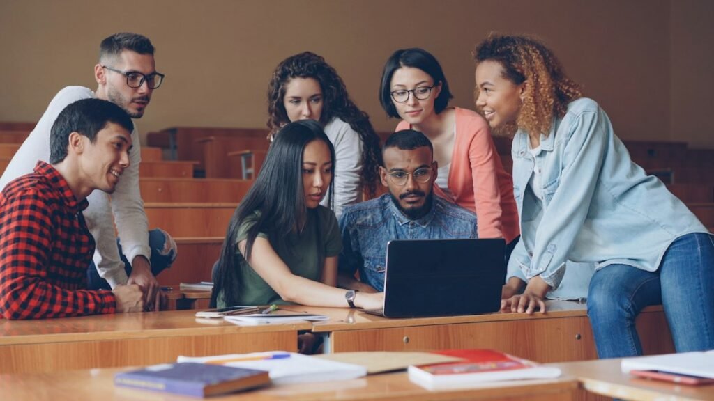College students gathered around a laptop