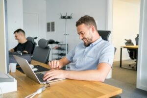 Developer working on a laptop in an office, the kind of coding and document work Claude Sonnet 5.5 is built for