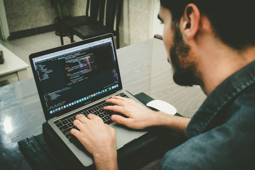 Developer writing code on a laptop, the kind of programming workflow Mistral Vibe is built for