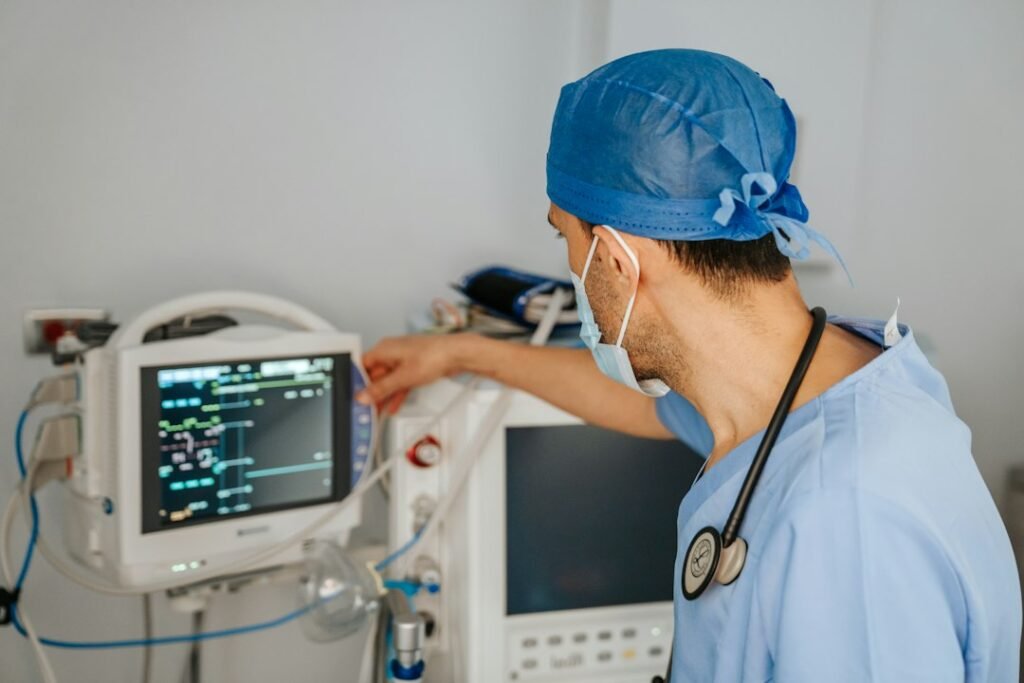 Doctor in scrubs looking at a computer monitor