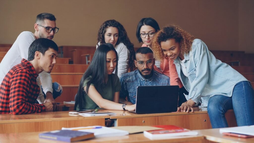 Group of students gathered around a laptop