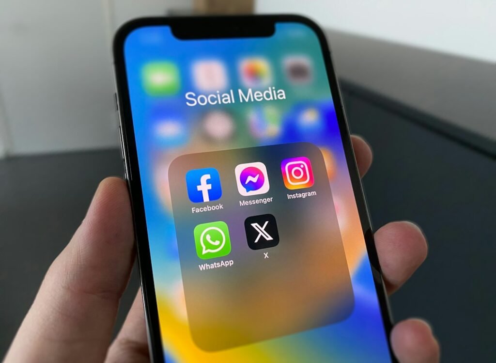Hand holding a phone with a social media feed open