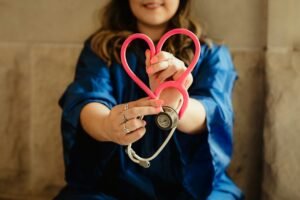 Healthcare worker holding a stethoscope shaped into a heart