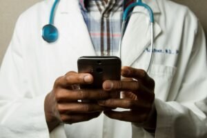 Healthcare worker with a stethoscope using a smartphone