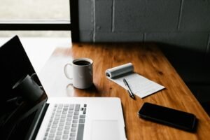 Laptop, coffee mug and smartphone on a work desk