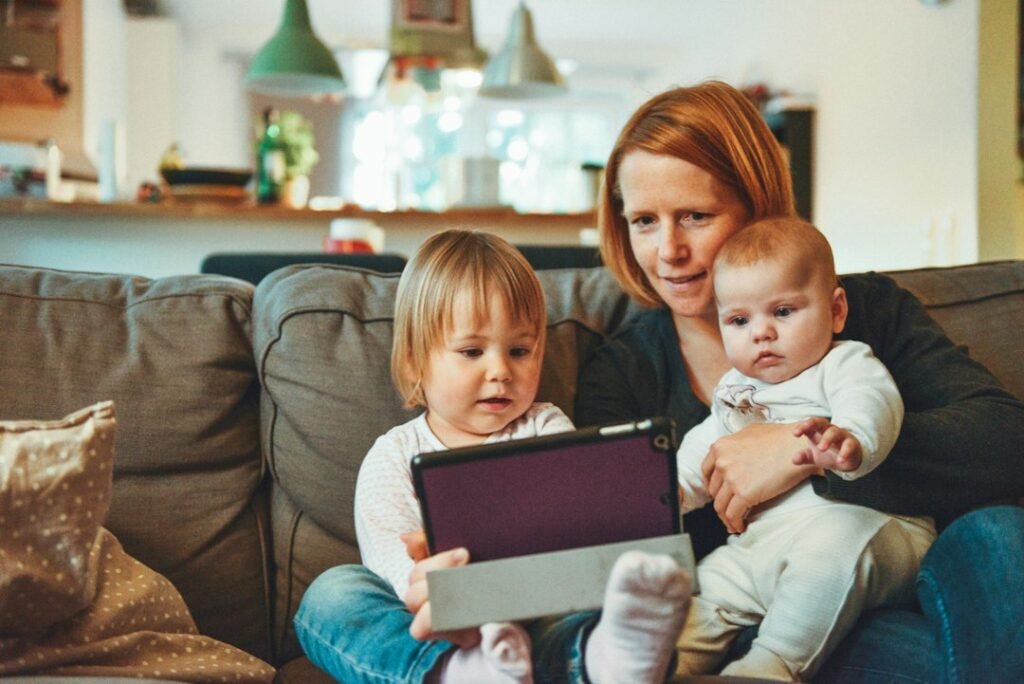 Mother and children watching a tablet together on a sofa