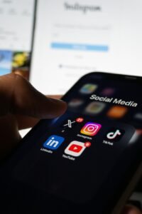Person holding a smartphone with social media on the screen
