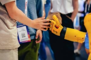 Person touching a robotic hand at a technology conference