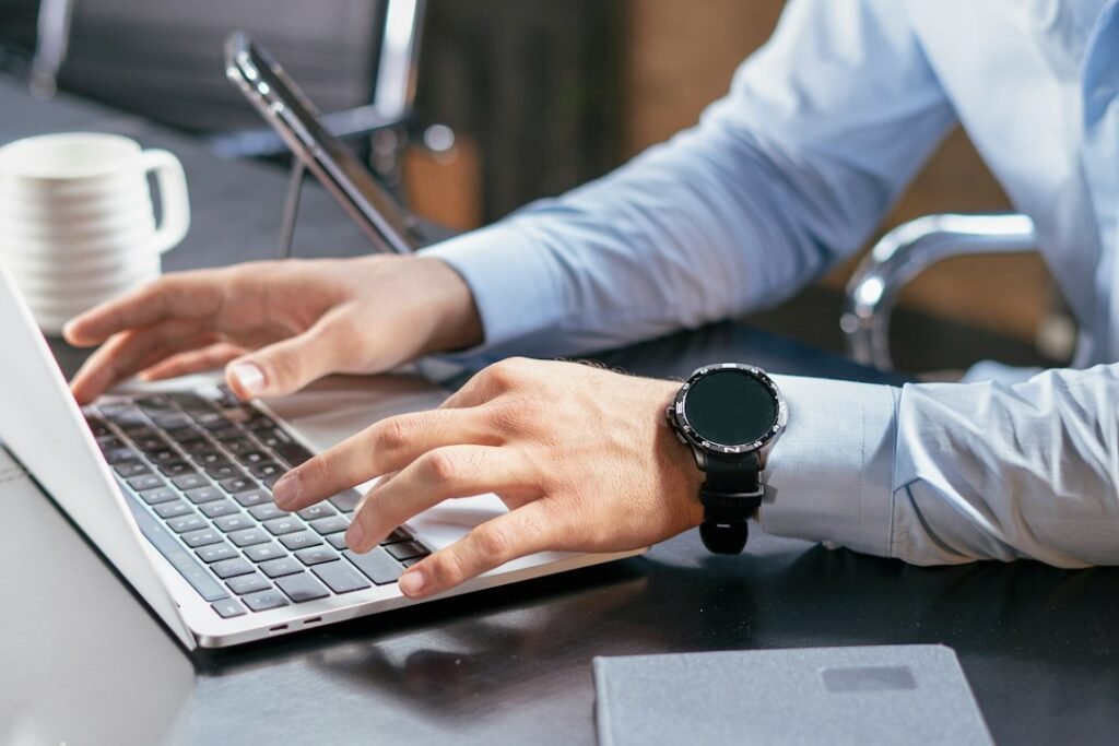 Person typing on a laptop at a desk in an office setting