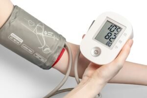 Person using a digital blood pressure monitor on their arm