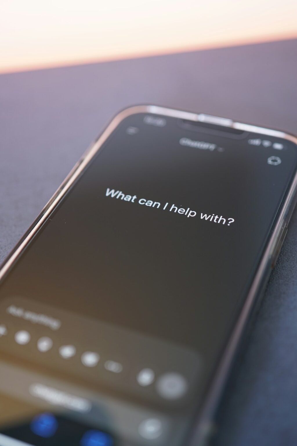 Smartphone screen displaying an AI chatbot interface asking what can I help with, representing conversational AI assistants like Grok