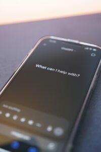 Smartphone screen displaying an AI chatbot interface asking what can I help with, representing conversational AI assistants like Grok