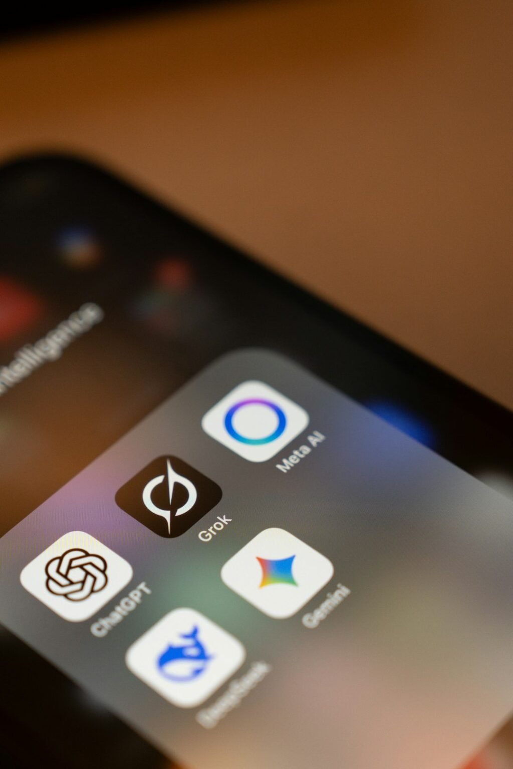 Smartphone screen showing AI assistant app icons including ChatGPT, Meta AI and Gemini, representing the competitive AI agent app market