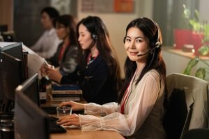 Smiling support agent wearing a headset at a computer