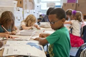 Student writing on paper at a desk
