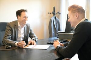 Two professionals discussing documents at an office desk, as when questioning an AI technology consultant before hiring
