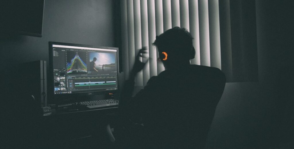 Video editor wearing headphones editing footage on a computer