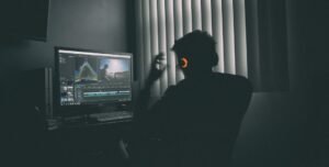 Video editor wearing headphones editing footage on a computer