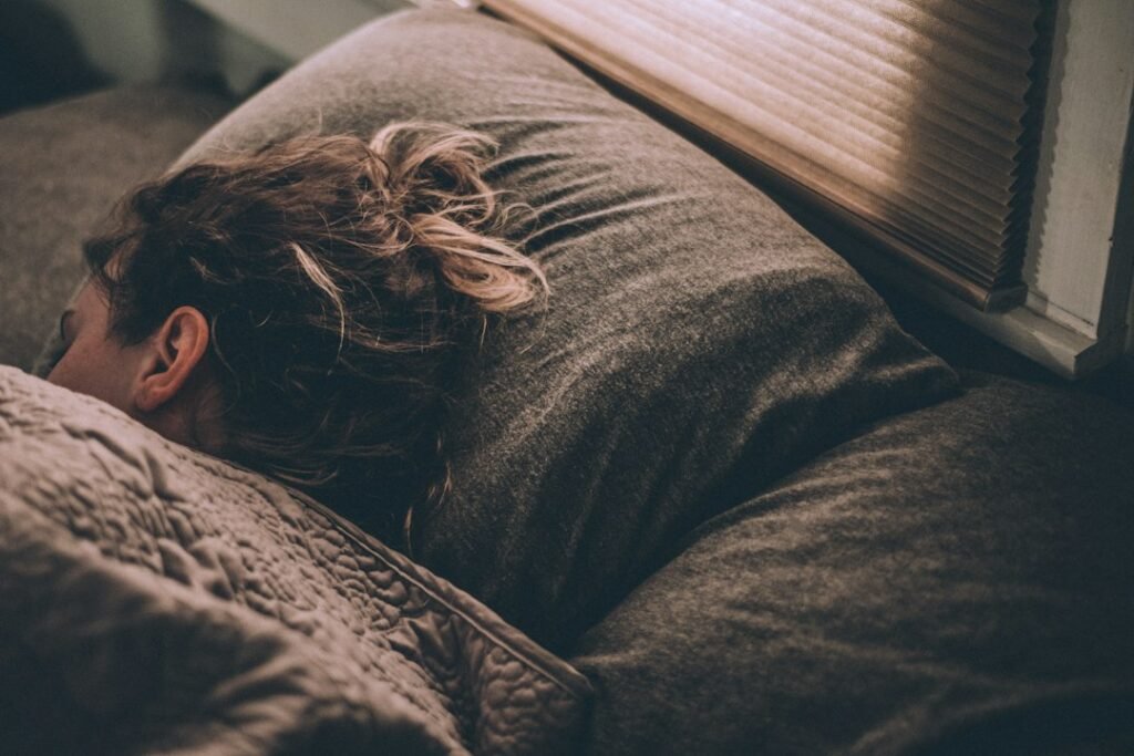 Woman sleeping in bed under blankets