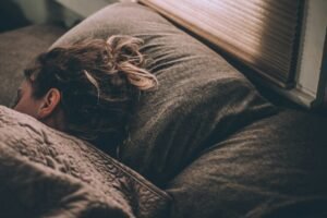 Woman sleeping in bed under blankets