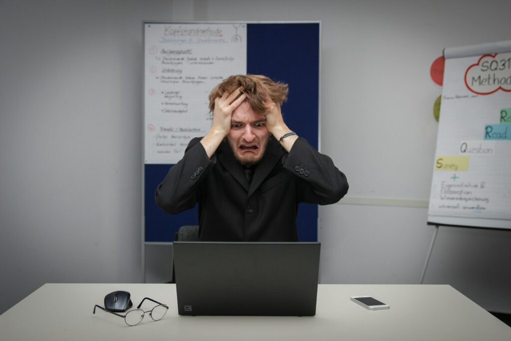 Man sitting in front of a laptop computer, troubleshooting Claude not working