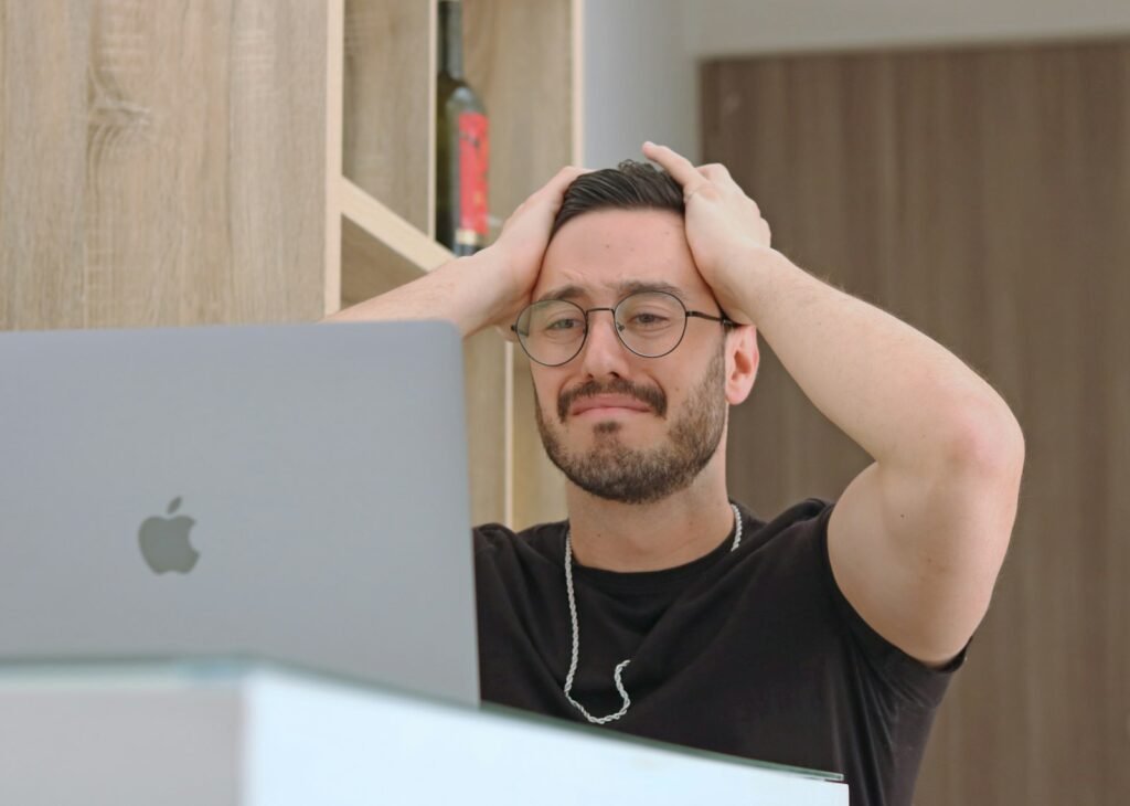 Man with glasses looking at a laptop, trying to fix ChatGPT not working