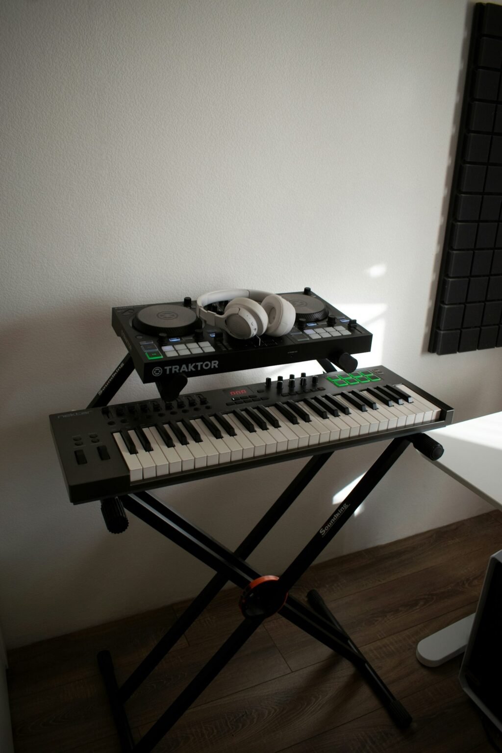 Music keyboard and DJ controller with headphones, representing Suno vs Udio AI music generators