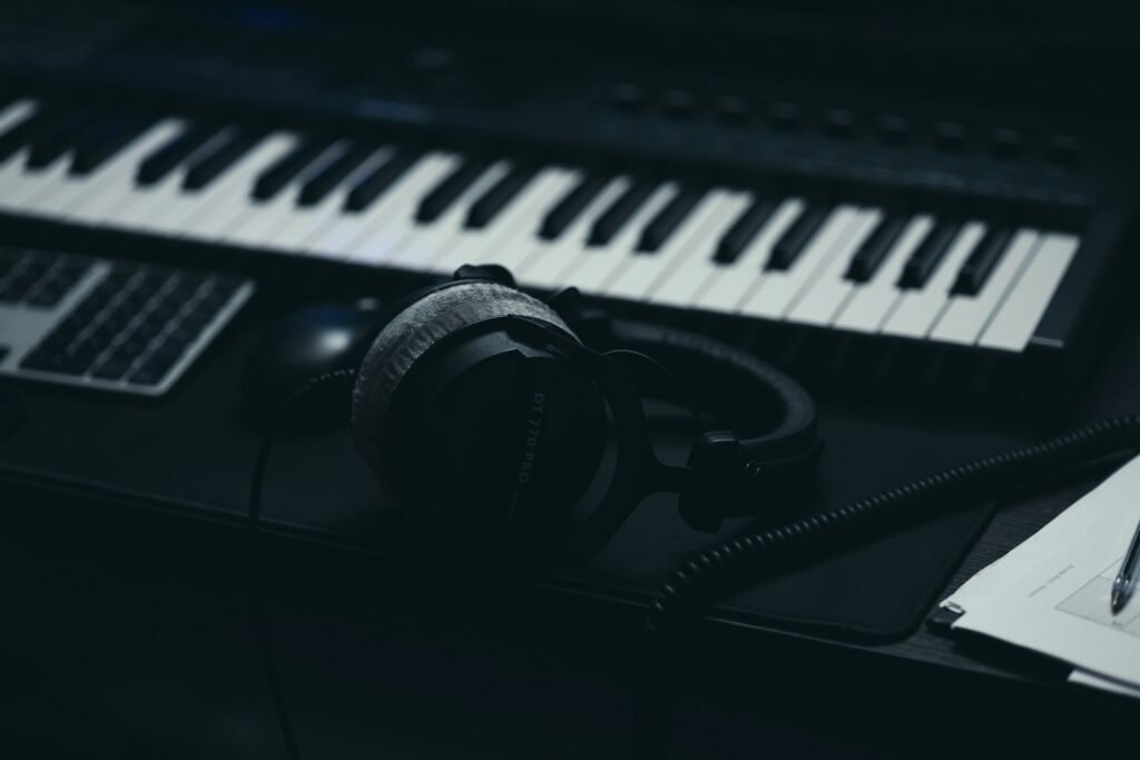 Music keyboard with headphones and a microphone, representing AI music on YouTube and its new labels
