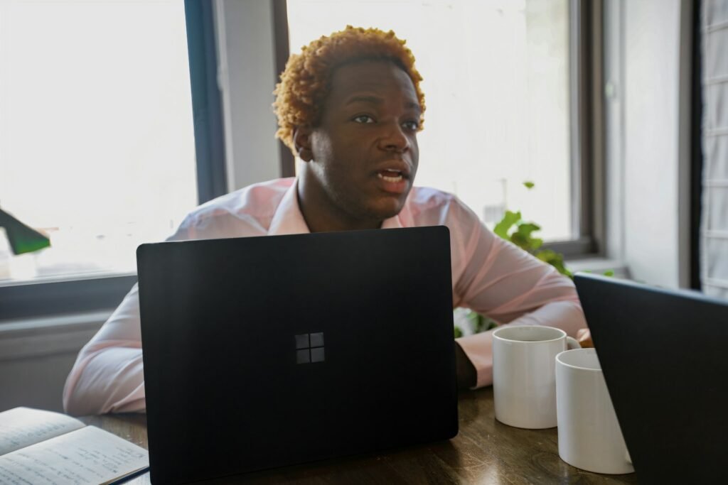 Person working at a desk on a Surface laptop, illustrating Microsoft Copilot pricing and plans