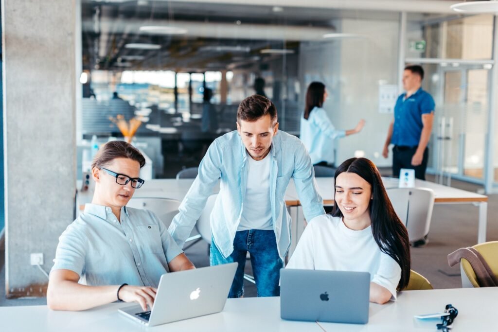 Team working around a table with laptops, representing Google's Gemini agent as a universal AI agent for work